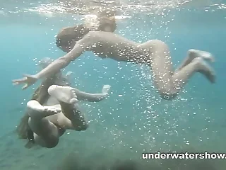 Julia and Masha are swimming nude in the sea